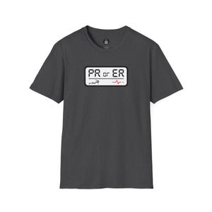 May include: Dark gray t-shirt with a rectangular graphic. The graphic reads "PR or ER" in white text, with a small illustration of a person running and a red heartbeat line. The shirt is made of a soft material.
