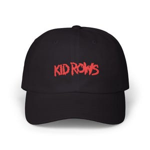 May include: Black baseball cap with the red text "KID ROWS" embroidered on the front. The cap has a curved brim and a rounded crown. The hat is made of a soft, durable material.