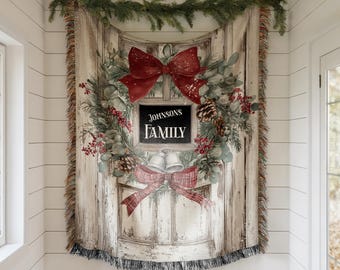 May include: A tapestry featuring a distressed wooden door design, adorned with a Christmas wreath, red bows, and the text "JOHNSONS FAMILY." The tapestry is fringed and decorated with greenery, pinecones, and berries, creating a festive holiday theme.