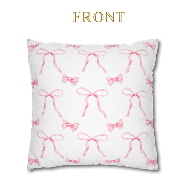 Puede incluir: Funda de almohada blanca con un patr&oacute;n de lazos rosas. La funda de almohada tiene la palabra "FRONT" impresa en dorado.