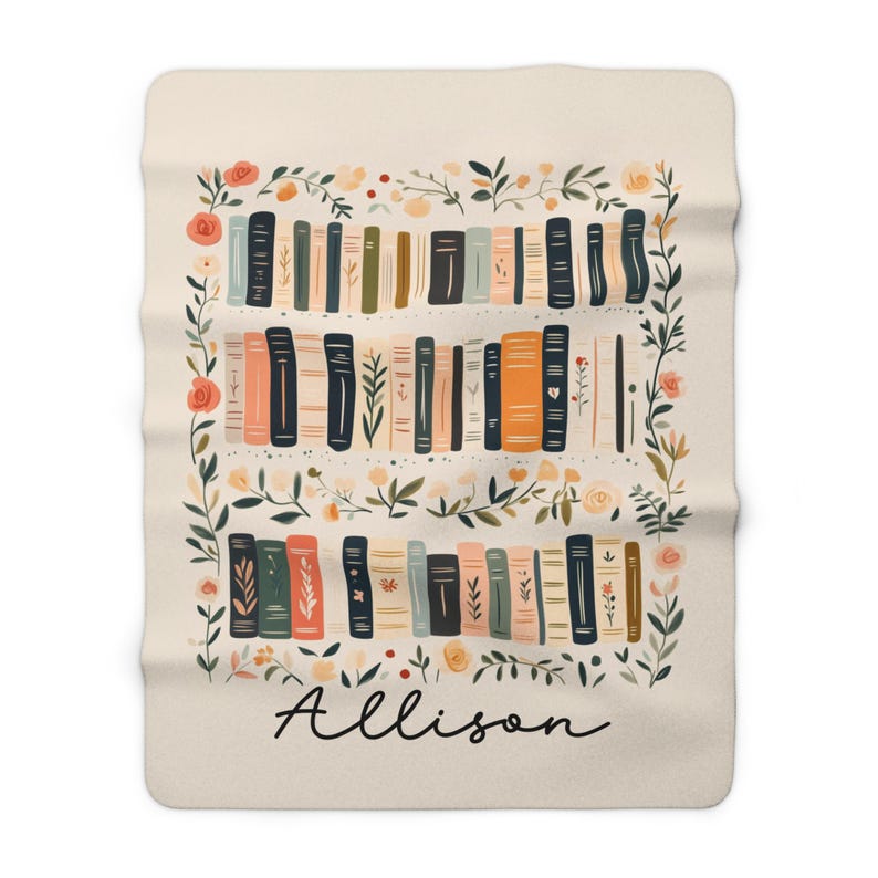 May include: A cream-colored fleece blanket with a floral border and a bookshelf filled with colorful books. The name "Allison" is written in black script at the bottom.
