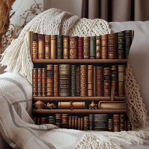 May include: A throw pillow with a design of a bookshelf filled with antique books. The books have ornate covers and spines with gold accents. The bookshelf has three shelves and is set against a dark background.
