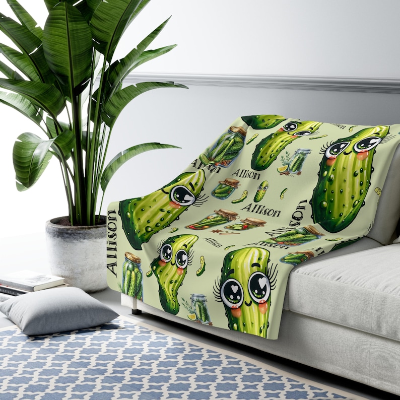 May include: A soft, green fleece throw blanket with a repeating pattern of cartoon pickles with big eyes and the name "Allison" printed throughout.