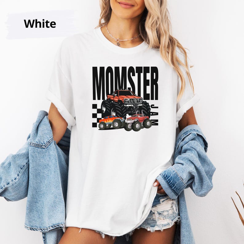 May include: White t-shirt with a black graphic of a monster truck and the text "MOMSTER JAM".