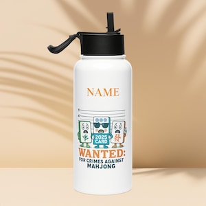 May include: White water bottle with a black lid and handle. The bottle features a cartoon design of three playing cards with the text "WANTED: FOR CRIMES AGAINST MAHJONG". The word "NAME" is printed above the design.