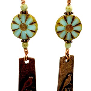 Long copper bird charm earrings with blue Czech glass flower bead with blue and bronze accent beads, whimsical copper boho bird earrings