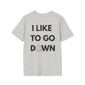 Puede incluir: Una camiseta gris claro con el texto "I LIKE TO GO DOWN" impreso en la espalda. La palabra "DOWN" tiene un símbolo de diana en la "O".