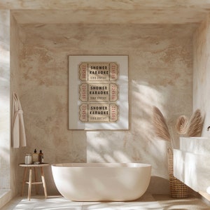 May include: Three vintage-style tickets with the text "Shower Karaoke One Entry" printed on them. The tickets are framed and hung on a beige wall in a bathroom setting.