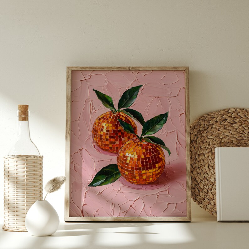 A framed oil painting of two vibrant oranges with a disco ball mosaic pattern, set against a textured pink background. The artwork exudes modern flair and vintage charm, perfect for kitchen or dining room decor.