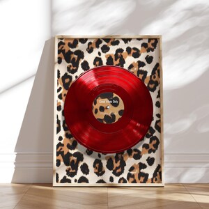 May include: A framed print of a red vinyl record with the text "Good Vibes Only" on a leopard print background.