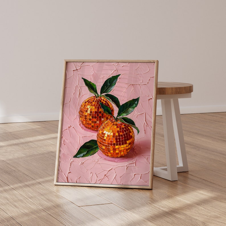 A framed oil painting of two vibrant oranges with a disco ball mosaic pattern, set against a textured pink background. The artwork exudes modern flair and vintage charm, perfect for kitchen or dining room decor.