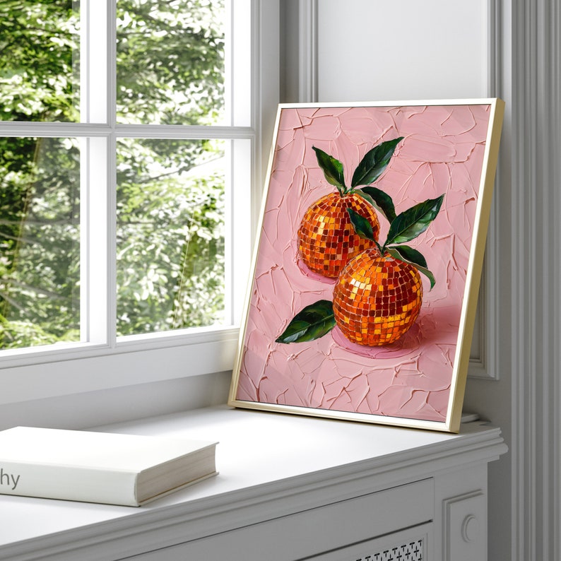 A framed oil painting of two vibrant oranges with a disco ball mosaic pattern, set against a textured pink background. The artwork exudes modern flair and vintage charm, perfect for kitchen or dining room decor.