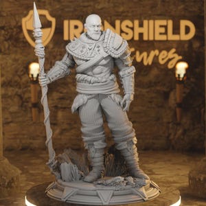May include: A grey, detailed, 3D printed figurine of a warrior holding a spear. The figurine is standing on a circular base with a textured surface. The background is a blurry image of a brick wall with the text "IRONSHEILD" visible.