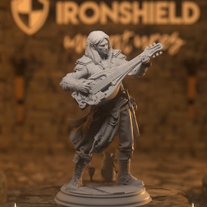 Pode incluir: Uma figura impressa em 3D em cinza, detalhada, de uma pessoa tocando um alaúde. A figura está em pé sobre uma base redonda. A pessoa está vestindo uma túnica longa e fluida e tem cabelos longos. O alaúde é decorado de forma elaborada.