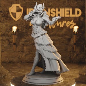 May include: A gray figurine of a woman in a fantasy outfit, holding a mask. The figure is wearing a corset, layered skirt, and boots. The background has the text "IRONSHIELD" and a shield logo.