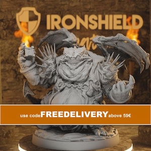 May include: A grey, unpainted resin miniature of a stout, winged demon with a wide, toothy grin, spiked shoulder armor, and a chain across its chest. The figure holds a small cube in one hand and stands on a circular base. The background features the text IRONSHIELD.