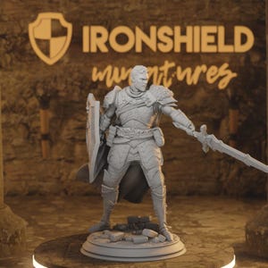 Puede incluir: Figura en miniatura gris de un caballero con armadura completa, sosteniendo una espada y un escudo. La figura está sobre una base circular. El fondo muestra el texto "IRONSHIELD miniatures".