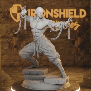May include: A gray, detailed, 3D printed figurine of a muscular elf with pointed ears, wearing a blindfold and bound by chains. The elf is in a fighting pose, with one arm raised and the other extended. The figurine is standing on a base with a textured surface.