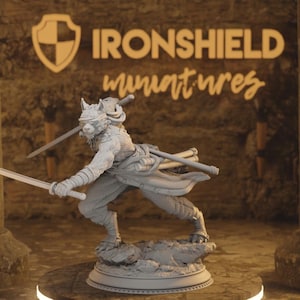 Puede incluir: Figura en miniatura gris de un guerrero lobo en pose dinámica, empuñando dos espadas. La figura está detallada con armadura y una venda en los ojos, de pie sobre una base rocosa. El texto "IRONSHIELD miniatures" es visible en el fondo.