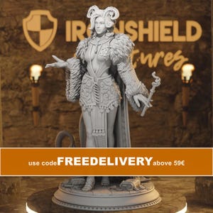 May include: A light grey miniature figurine of a female character with horns, wearing a textured bodice, a fur-trimmed cloak, and a skirt with decorative tassels. The character holds a thin, twisted staff in one hand and stands on a circular base.