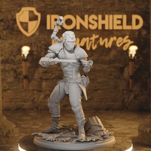 Op de afbeelding: Een lichtgrijs onbeschilderd miniatuurfiguur van een futuristische krijger op een ronde voet. Het figuur draagt een gesegmenteerd pantser, een helm met vizier en houdt een zwaard in de hand met een mechanische grijparm op de rug.