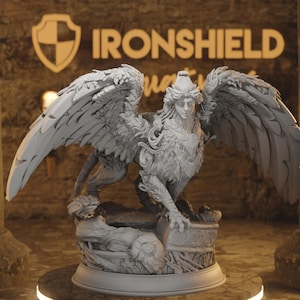 May include: A detailed, grey sculpture of a sphinx with large, feathered wings. The sphinx has a human face and a lion's body, perched on a decorative base. The sculpture is set against a blurred background with the text "IRONSHIELD".