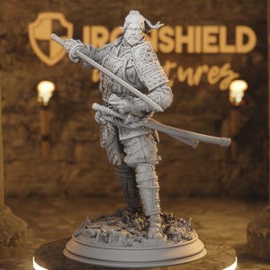 Puede incluir: Figura gris de un guerrero samurái con armadura completa, sosteniendo dos katanas. La figura está sobre una base detallada, con el logotipo de Iron Shield Pictures visible en el fondo. El samurái tiene barba y está en una pose dinámica.