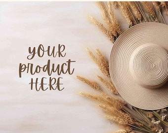 May include: A straw hat with a wide brim sits on a white wooden surface with dried wheat stalks surrounding it. The text "your product here" is written in brown cursive on the surface.