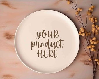 May include: A white ceramic plate with the text "your product here" written in brown cursive on a pink background with a sprig of dried yellow berries.