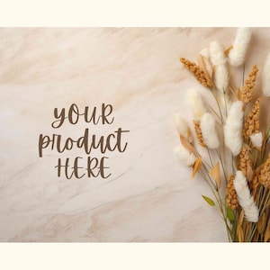 Pode incluir: Um fundo bege com o texto "your product here" escrito em itálico marrom. Um buquê de flores secas brancas e bege está no canto superior direito da imagem.
