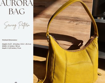 May include: Mustard yellow Aurora bag sewing pattern. The bag has a curved shape with a zipper closure and a shoulder strap. Finished dimensions are: Height: 8 1/2 - 10 inches, Width: 11 inches, Depth: 3 1/2 inches. The text "AURORA BAG Sewing Pattern" is visible.