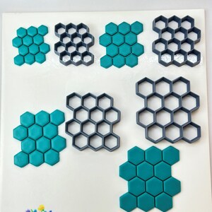 May include: Set of eight grey plastic honeycomb cookie cutters and three teal blue fondant honeycomb shapes. The cutters are in various sizes and the fondant shapes are in two sizes. The image includes the text "Lavin's Design" and "805".
