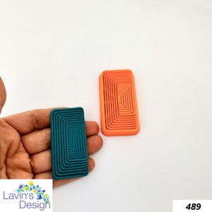 May include: Two rectangular shapes with concentric circles, one is teal and the other is orange.