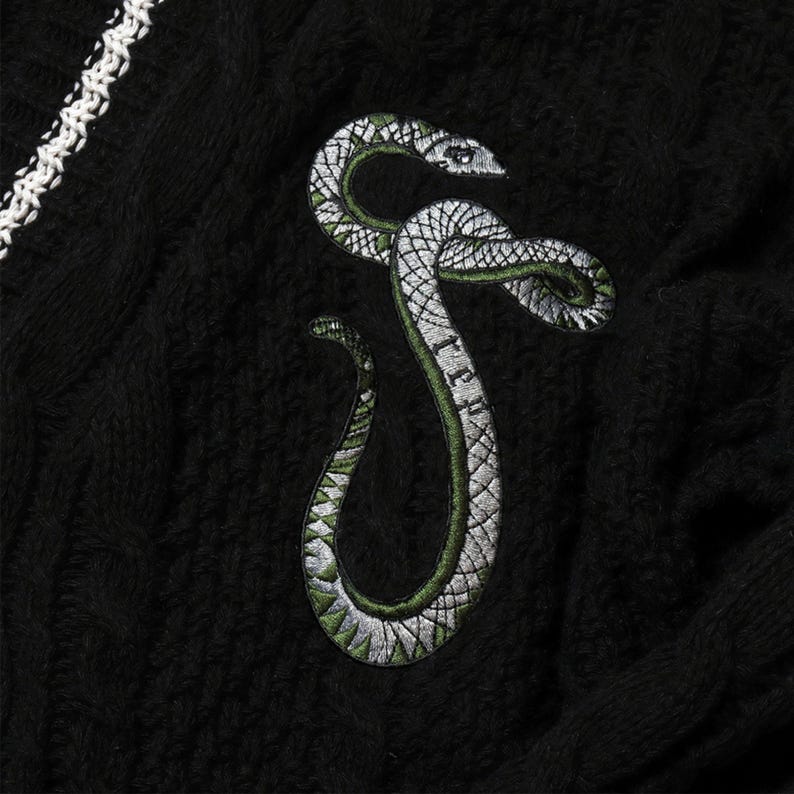 May include: Black sweater with a green and silver embroidered snake design.