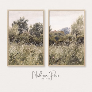 Puede incluir: Dos pinturas de paisaje enmarcadas que representan un campo verde exuberante con árboles y una casa lejana en el fondo. Las pinturas están en un marco de madera claro y tienen un estilo suave de acuarela.