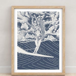 Puede incluir: Una impresión artística enmarcada que representa a una mujer surfeando sobre una ola. La obra de arte está en tonos azules y blancos, con una ilustración detallada del surfista, el océano y el cielo nublado. La firma del artista, "mamaseasta", es visible.