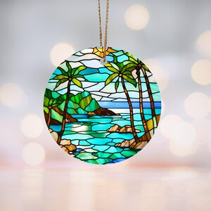 Könnte beinhalten: Runder Keramik-Anhänger mit einem Buntglas-Design einer tropischen Strandszene mit Palmen, blauem Wasser und grünen Hügeln.