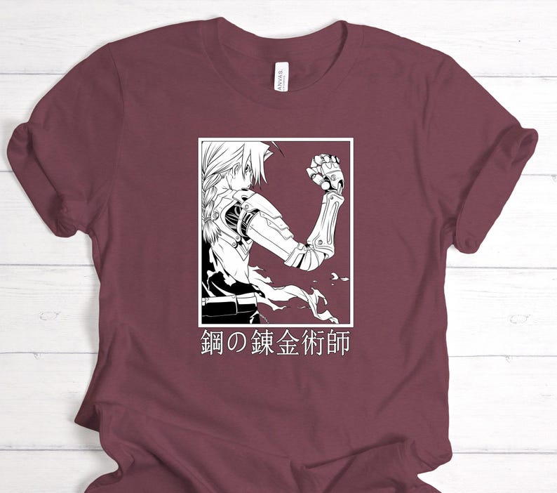 May include: Maroon t-shirt featuring a black and white illustration of an anime character with a mechanical arm. The graphic is in a white rectangle, with Japanese text below. The shirt has short sleeves and a crew neck.