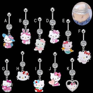 May include: A collection of eleven silver-toned navel rings labeled A through K, each featuring a dangling charm of a white cat character with pink accents and a clear crystal bead on the barbell. One inset shows the jewelry worn in a navel.