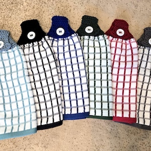 May include: Set of seven kitchen towels with crocheted button loops. The towels are white with different colored checkered patterns: blue, black, navy, green, red, and gray.