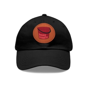Peut inclure: Casquette de baseball noire avec un patch rouge et orange représentant un seau rouge et le texte "jimmy BUCKETS!"