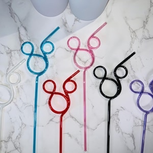 May include: A collection of colorful, reusable straws in various shades, including white, blue, red, pink, black, and purple. Each straw features a Mickey Mouse-inspired design. The straws are made of a clear, bendable material.