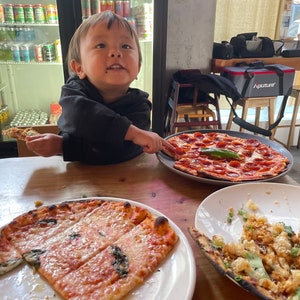 Little boy enjoys a beautiful spread of pizzas made from our unique sourdough starter