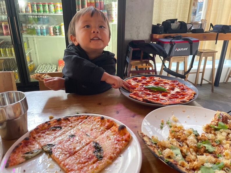 Little boy enjoys a beautiful spread of pizzas made from our unique sourdough starter