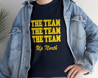 May include: A navy blue t-shirt with the text "The Team The Team The Team Up North" in yellow.