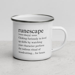 Op de afbeelding: Een witte emaille mok met een zwart-wit grafisch ontwerp. De grafiek is een definitie van het woord "runescape" dat luidt: (roon-skayp) zelfstandig naamwoord Snel klikken om vaardigheden te verhogen door te kijken hoe je personage het saaie ritueel van hout hakken uitvoert... urenlang.