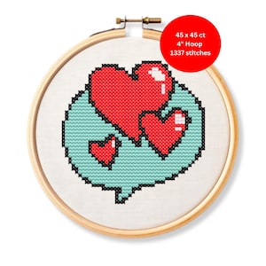 May include: A cross-stitch embroidery hoop featuring a design of three red hearts within a light blue speech bubble. The design is stitched on white fabric and framed by a wooden hoop. The text on the image says: 45 x 45 ct, 4" Hoop, 1337 stitches.