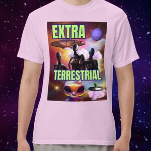 May include: Pink t-shirt with a graphic print of a spaceship, aliens, and the text "EXTRA TERRESTRIAL".