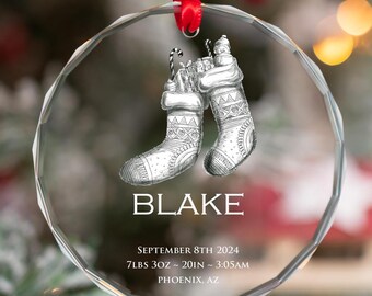 May include: A clear glass Christmas ornament with a white stocking design and the text "BLAKE SEPTEMBER 8TH 2024 7LBS 3OZ - 20IN ~ 3:05AM PHOENIX, AZ".