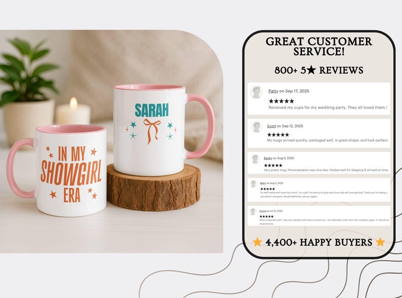 May include: Two white ceramic mugs with pink interiors and handles. One mug has "IN MY SHOWGIRL ERA" in orange text. The other mug has "SARAH" in teal with a bow graphic. Both mugs sit on a wooden coaster.